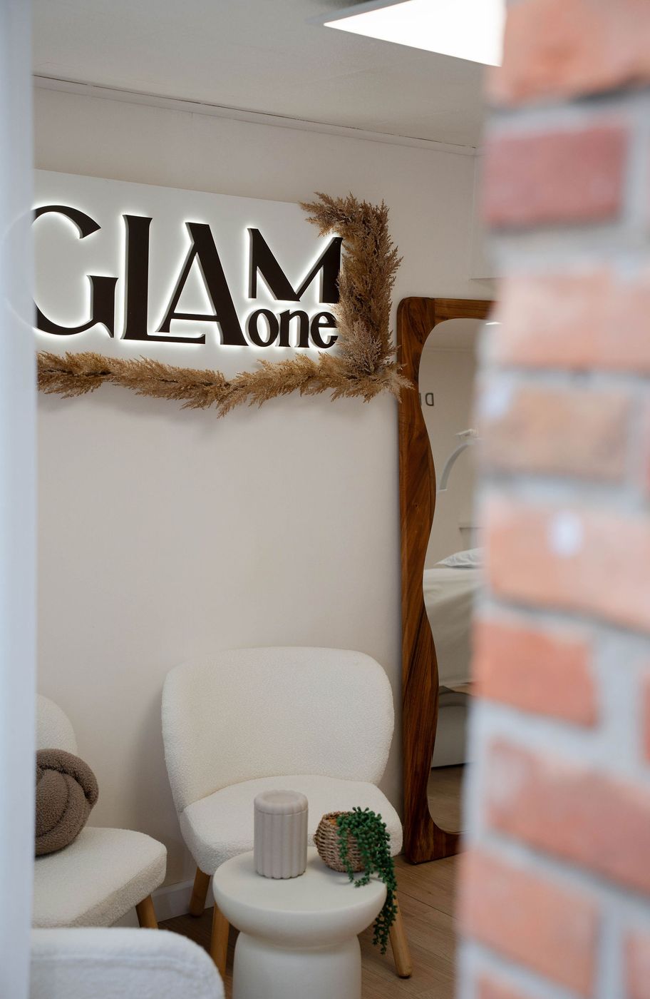 De wachtruimte met het verlichte GLAM ONE logo